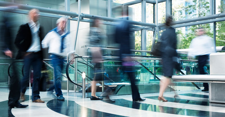 Business travelers crossing a bright office lobby