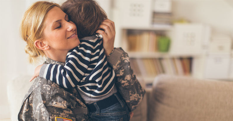 A soldier hugging her young son at home